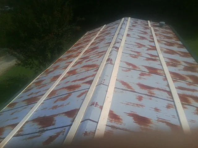 Rusted metal roof panels with new wood purlins before replacement — Storm Damage Roof Repair in Ivydale by Roofing Brothers
